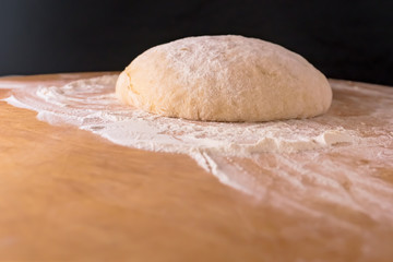 Dough on a wooden Board and with a black background