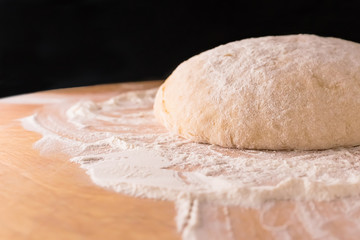 Dough on a wooden Board and with a black background