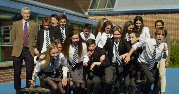4K End of term class portrait with excited students & teachers running towards camera. Slow motion