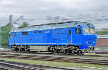 Fototapeta na wymiar Blue locomotive diesel train at high speed rides by rail.
