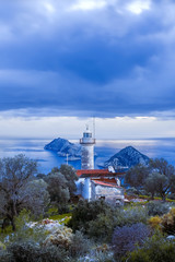 A lone white lighthouse on the sea coast