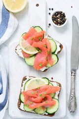 Smoked salmon, cream cheese and cucumber toast sandwiches on white. Top view