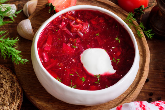 Borscht soup in white bowl with sour cream. National Ukrainian and Russian cuisine food. Closeup view