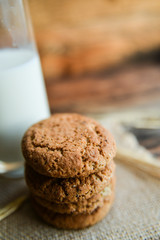 fresh homemade oatmeal cookies on wooden background with spikes of oats