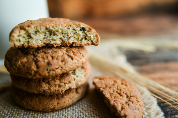 fresh homemade oatmeal cookies on wooden background with spikes of oats