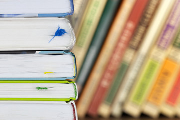 Closeup of stack of books on the bookshelf background with colored books.