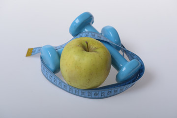 Dumbbells in bright green color, measure tape and fruit