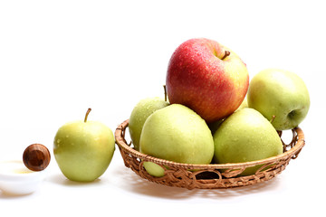 Apples in wicker bowl isolated on white background, close up