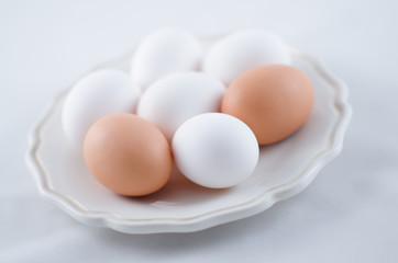 Chicken white and brown eggs on the plate