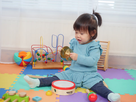 baby girl play cymbals at home