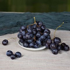 Bunches of blue grapes on the small plate