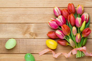 Spring easter tulips in bucket on wooden vintage background.