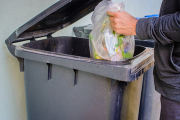 Men putting garbage in garbage bin