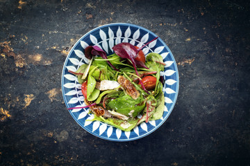 Traditional Italian lettuce with tomatoes and fig as top view on a plate with copy space