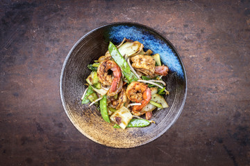Traditional stir-fried Thai phak kung as top view in a bowl with copy space