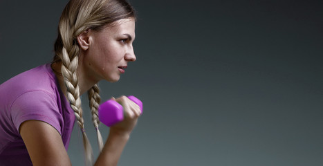 young slender girl works with small dumbbells performing exercises. concept of a healthy lifestyle....
