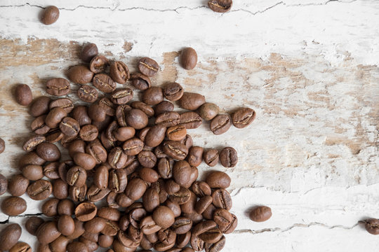 coffee beans scattered on the rough wooden surface background