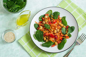 Vegetarian salad with chickpea, carrot, sweet pepper and spinach