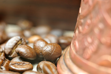 geröstete Kaffeebohnen neben einem Mokkakännchen