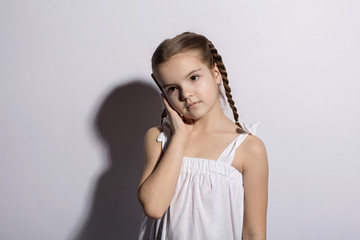 Happy little little girl caucasian talking on telephone over white background