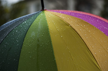  Close-up  umbrella in rainbow colors in rainy autumn day, blur focus