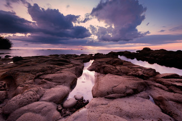 sunset seascape with natural coastal rocks durin monsoon at Kudat Borneo, Malaysia.