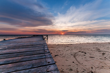 Naklejka na ściany i meble seascape sunset with wooden jetty.