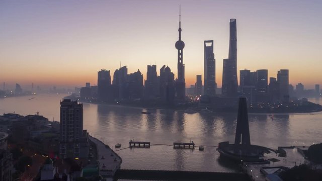 Panoramic Shanghai Skyline Silhouette at Dawn. Lujiazui Financial District and Huangpu River. China. Aerial Hyper Lapse. Drone is Flying Upward and Forward. Establishing Shot..