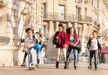Fototapeta premium Inline skaters and skateboarders riding in city
