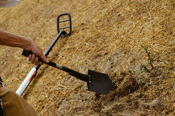 Electronic metal detector working on outdoors background. Closeup photography of searching process