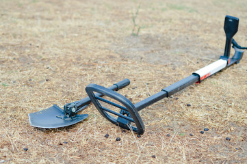 Electronic metal detector working on outdoors background. Closeup photography of searching process