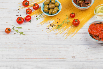 Ingredients for preparation pasta spaghetti - tomato, olive oil, spices, herbs, green olives, tomato sauce