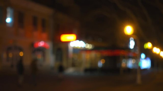 City street at night, people walk near night club and restourants.