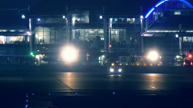 Airplane maneuvers on the runway at night, preparing to take off
