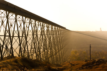 Steel train bridge at sunrise through the fog