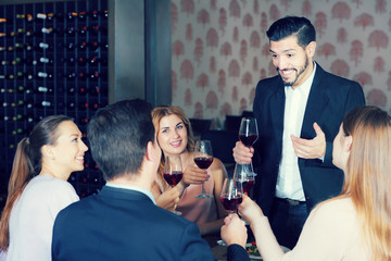 Young man pronouncing toast in cozy restaurant
