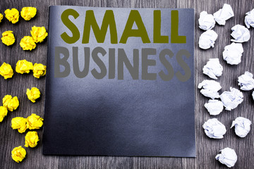 Hand writing text caption inspiration showing Small Business. Business concept for Family Owned Company Written on notepad note notebook book wooden background with sticky folded yellow and white