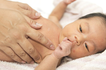 Fototapeta na wymiar 沐浴後　新生児の体に保湿剤を塗る