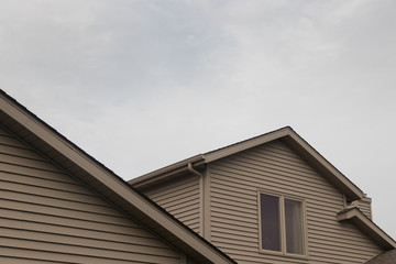 Detail of beige house with cloudy sky.