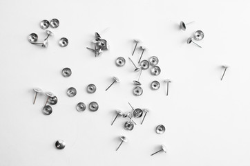 small nails are randomly scattered on a white surface