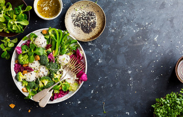 Frischer Salat mit Reis und Gemüse auf Draufsicht des dunklen Hintergrundes mit Platz für Text. Gesundes Essen.