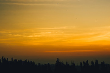 Landscape with dramatic light - beautiful golden sunset with saturated sky and clouds.