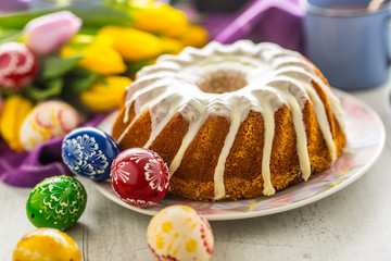 Easter Cake. Traditional ring marble cake withe easter decotation. Easter eggs and spring tulips.
