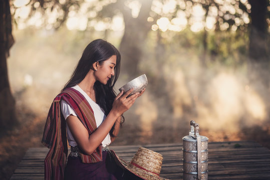 Local asia thai woman sitting and drinking water in the local house