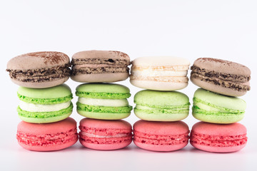 pink, green, white, coffee cookies lie in a row isolated on white