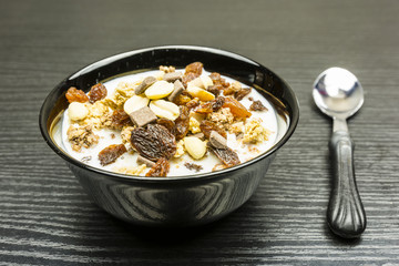 Roasted muesli with peanuts, chocolate and raisins with milk.