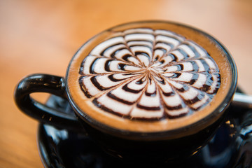 Hot latte with latte art in black mug