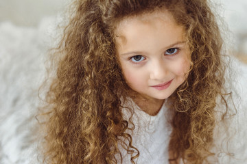 portrait of adorable curly kid looking at camera