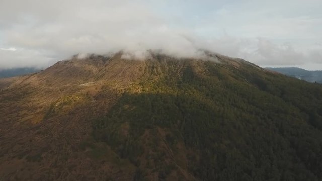 Volcano traces of lava on the ground, mountains, sky with clouds. Aerial view of Mount Batur Volcano in Kintamani. Bali volcano, also referred to as Kintamani is popular sightseeing destination in