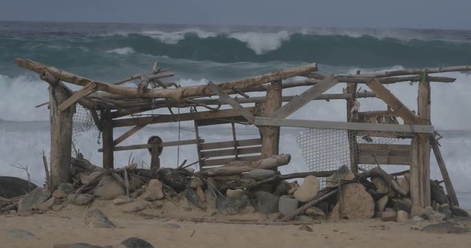 Destroyed shack on Aruba beach before crashing waves